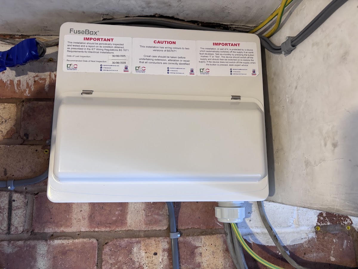 The finished consumer unit closed up and labelled with the inspection dates — tested, certified and handed over.